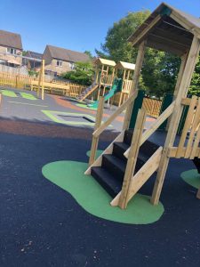 timber jigsaw play tower on wet pour playground