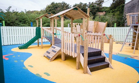 Childrens play area including steps which lead to a clatterbridge and a slide