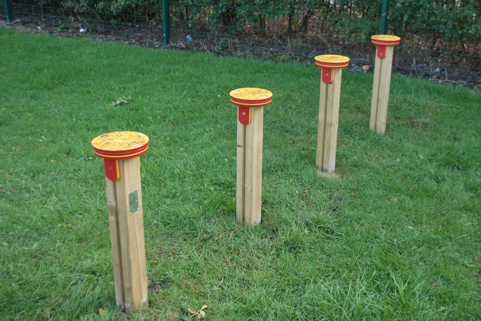 Four wooden leapfrog posts on grass