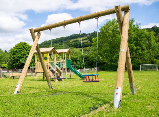 Timber playground equipment supported by steel post shoes
