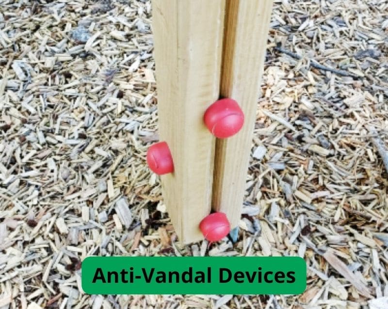 Red bobbles on a wooden post protecting fixings from vandals