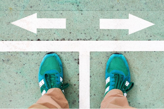 Feet on a path with two white arrows pointing left and right