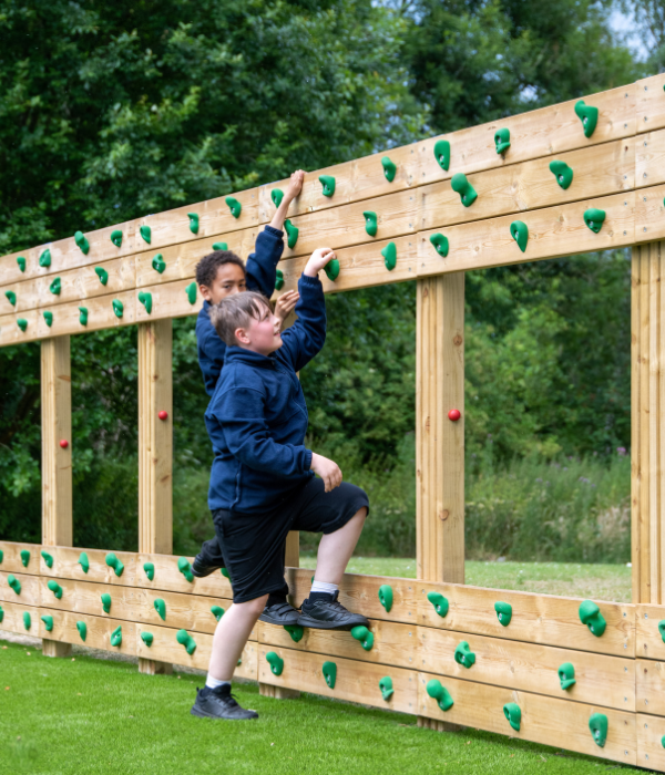 school children climbing on playground equipment