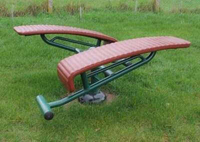 Green and red metal exercise structure on grass