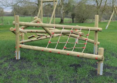 Wooden jungle climbing play structure on grass