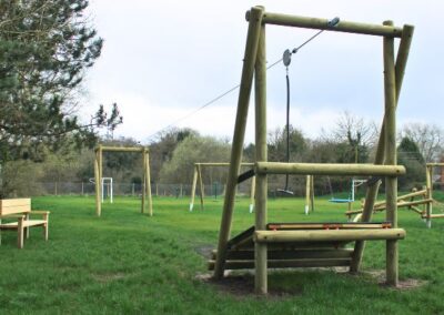 Timber-based zip-wire structure set on grass