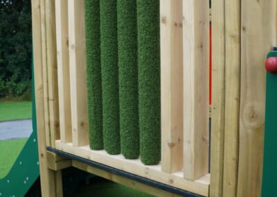 grassy textured rollers on the side of a wooden play tower