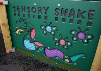 Green sensory snake play board featuring multiple textures