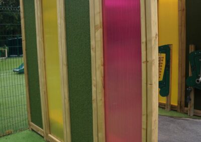 Side view of a multi-coloured playground sensory tunnel
