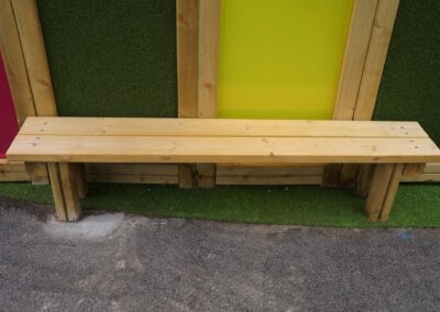 Wooden bench inside a multi-coloured sensory tunnel
