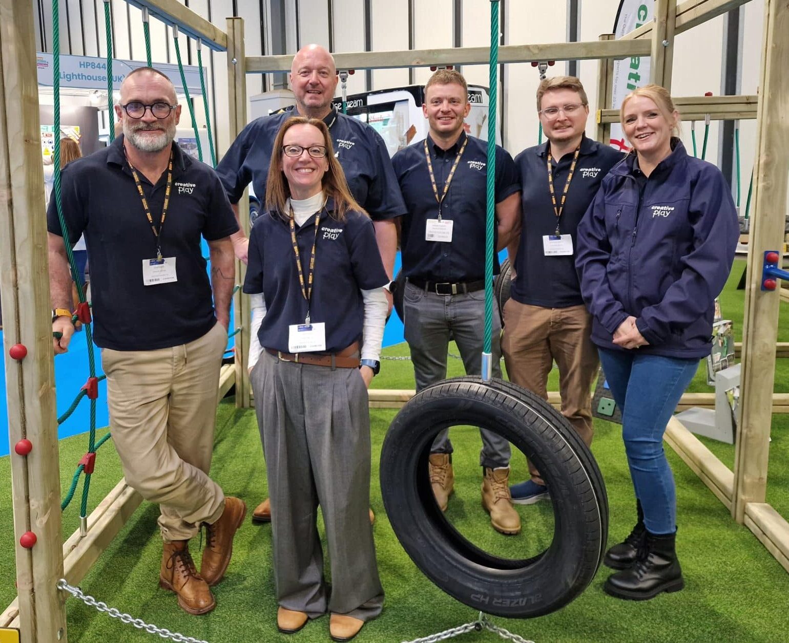 Group of employees stood around timber play equipment at a trade event