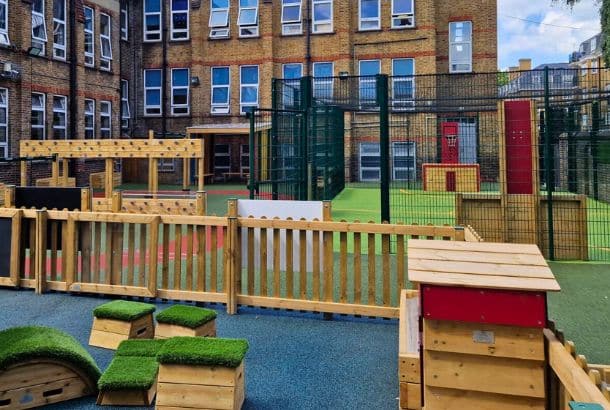 Timber fence surrounding timber play equipment at school playground