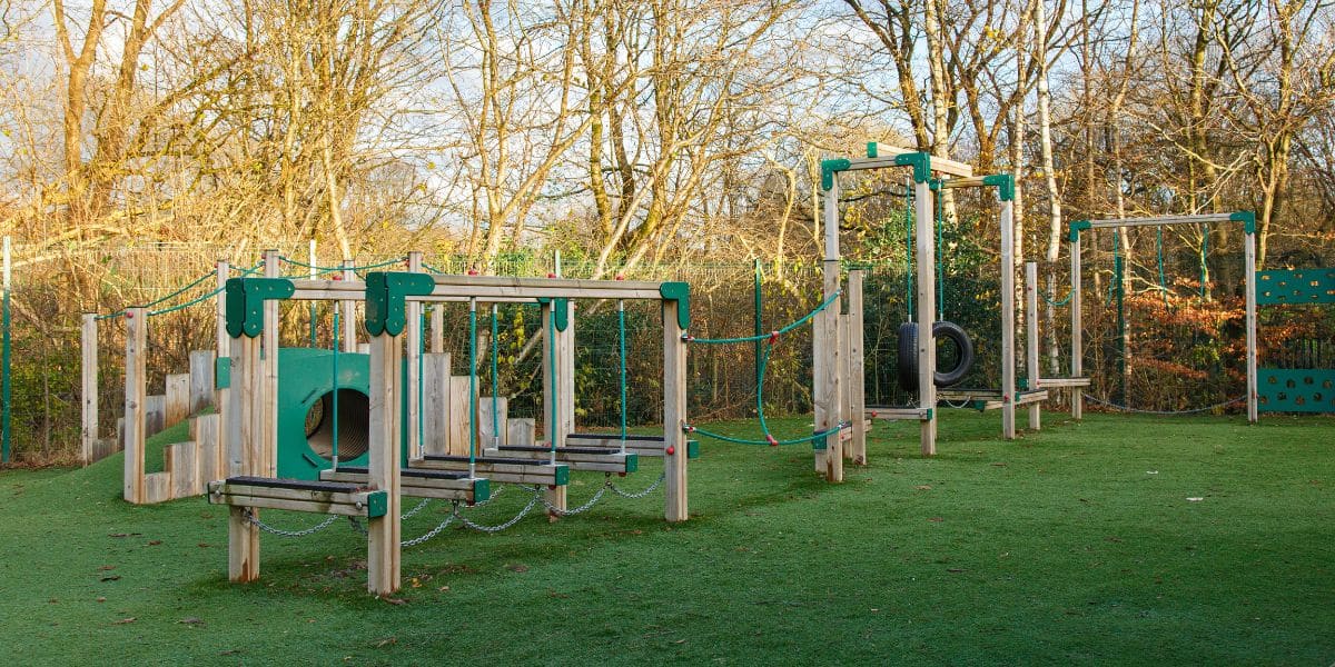 This image depicts two pieces of playground equipment, a trim trail and a mound tunnel.