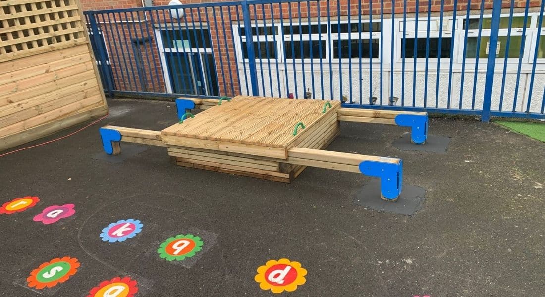 This image shows a timber sandbox with sliding lid