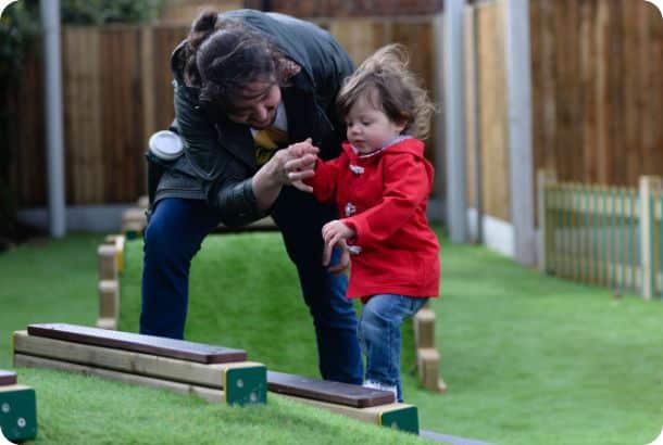 child climbing steps with help from an adult