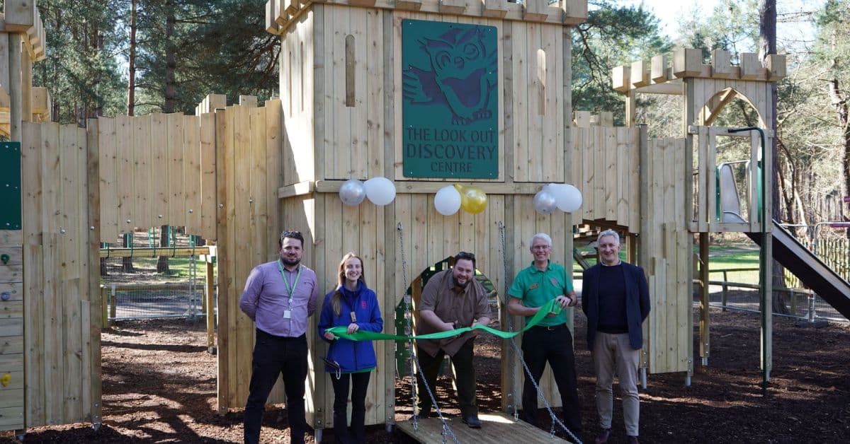 The image shows the Look Out Discovery Centre team and council colleagues, preparing to cut the ribbon to open the new play fort.