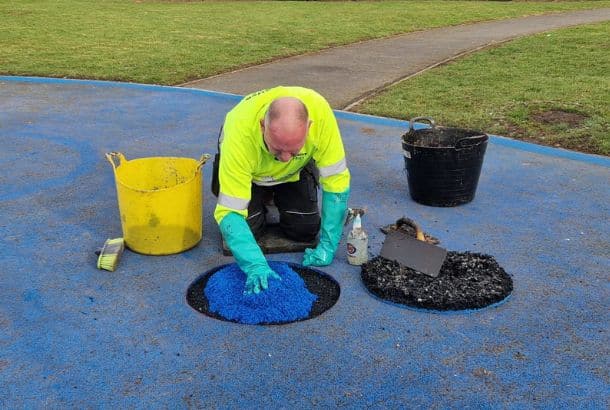 This image shows a creative play employee repairing an area of wetpour surfacing
