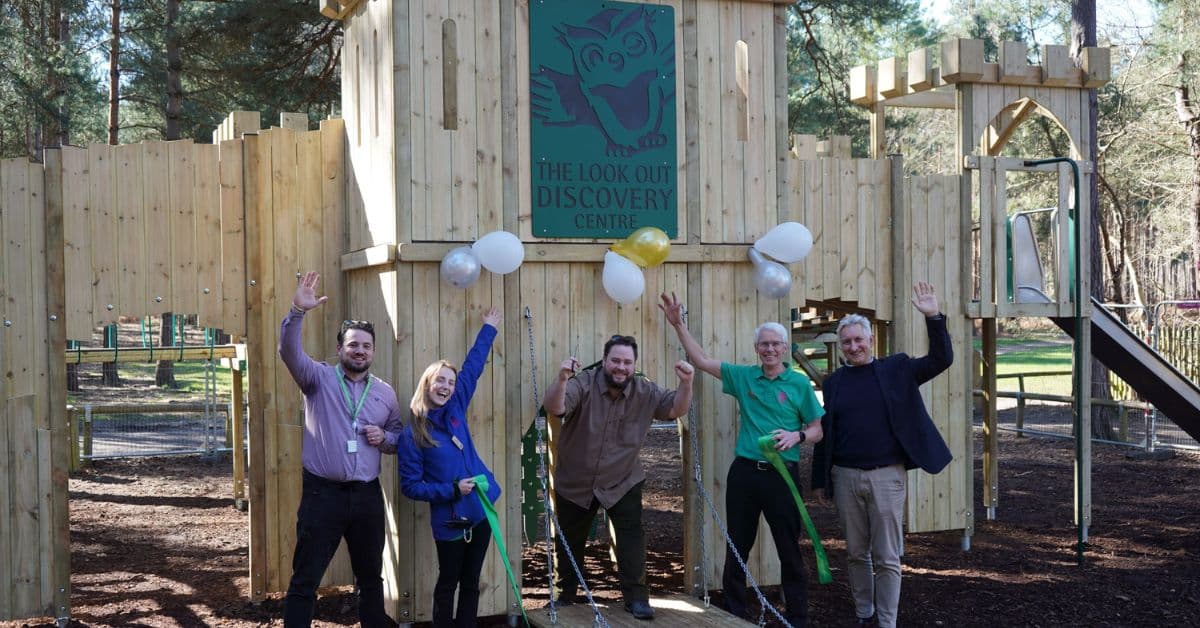 The image shows the Look Out Discovery Centre team and council colleagues, preparing to cut the ribbon to open the new play fort.
