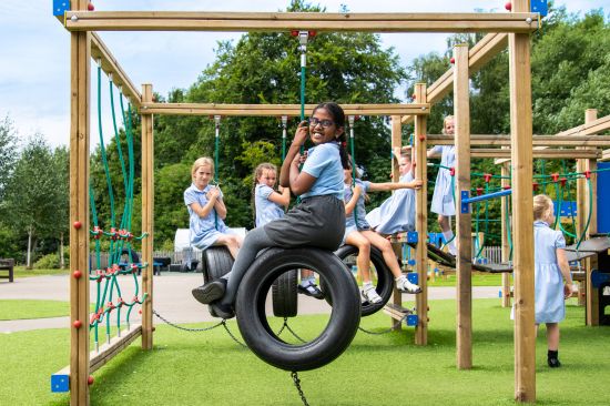 This image shows several young school girls playing on a dart activity play centre 