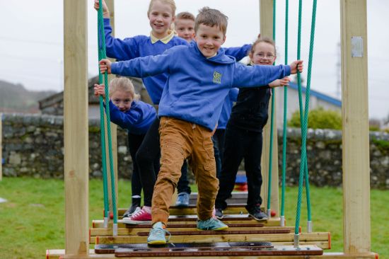 This image shows children on a rope bridge in a playground din the UK 