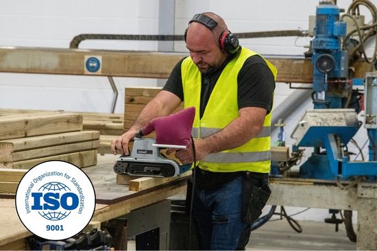 This image shows a male Creative Play factory worker sanding down a piece of timber wood. 