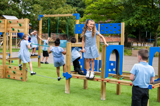 This image shows primary school children playing on a adventure trail playground equipment 