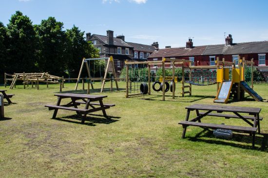 This image shows a beer garden our door play area with multiple pieces of playground equipment