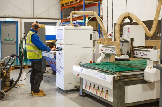 This image shows a male worker using a CNC engraving machine in our factory 