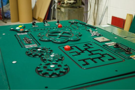 This image shows a male factory worker using a CNC machine 