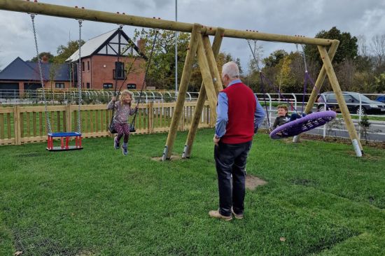 This image shows a grandfather and his grandchildren at a local council playground 