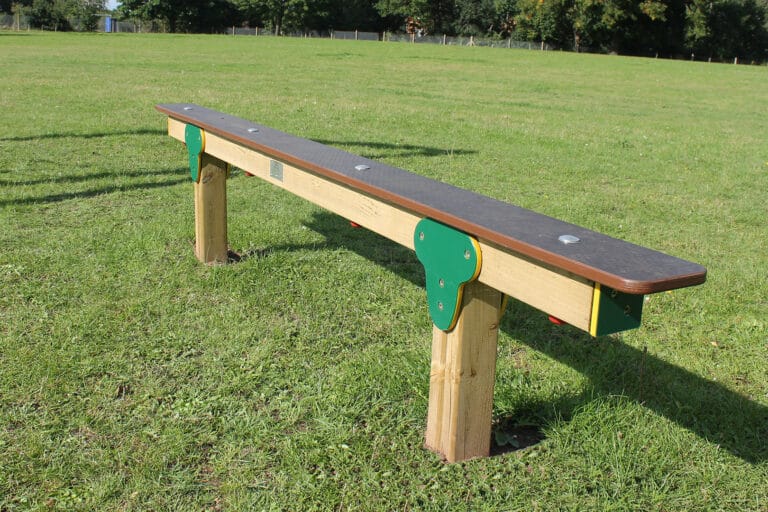 Wooden balance beam on grass surface