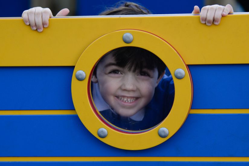 New Website Imagery - Education Sector (2) This image shows a young boy poking his head through a playground window