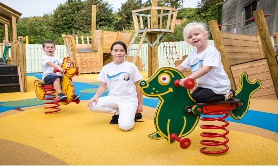 Three kids enjoying playground equipment