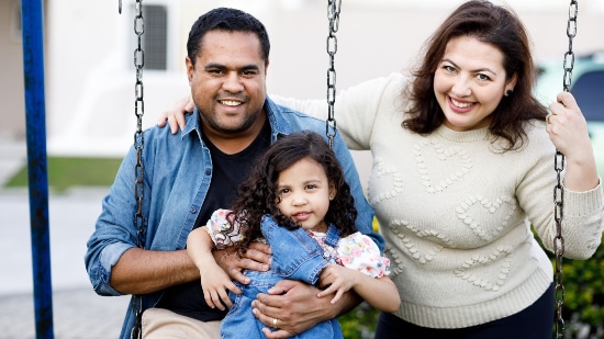 Mother, father and daughter son a swing outdoors