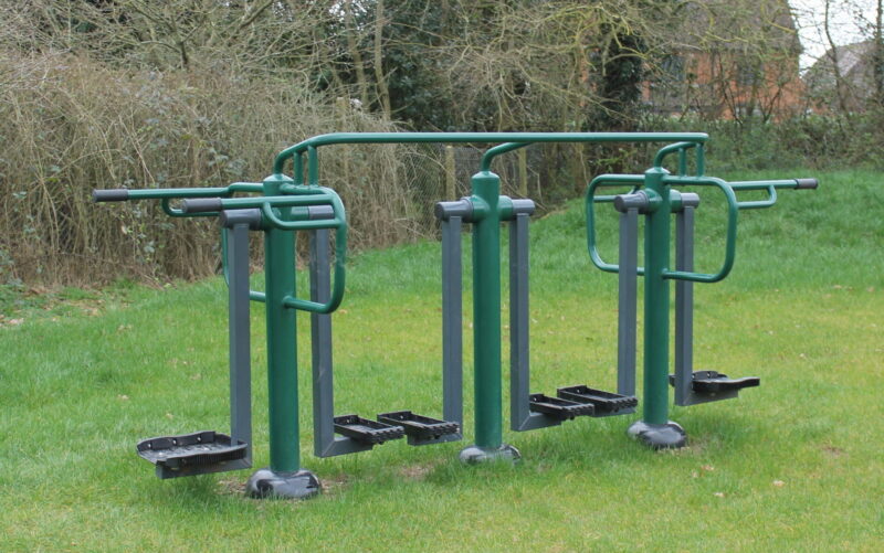 Green metal exercise equipment in a park
