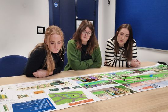 This image shows three female teachers reviewing playground design documents 