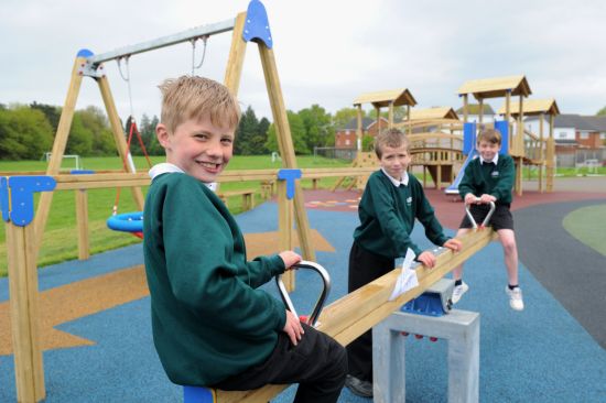 This image shows three boys on a seesaw