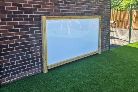 This image shows a white board on a brick wall