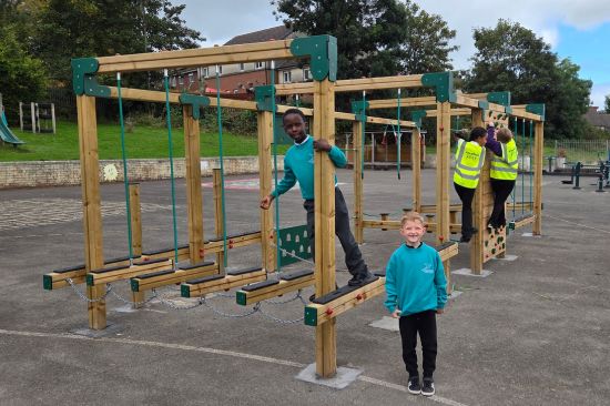 This image shows the after of the playground project at Greenway Primary School with children playing on a Spey Climbing frame