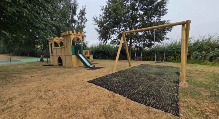 This image shows a bespoke castle tower and combi swing at HPB Upper Norton on grass mats