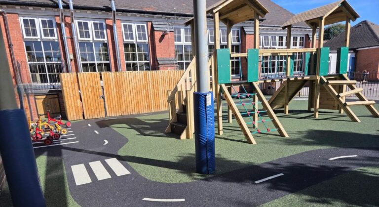 This image shows the completed playground at Heathfield Primary School on green and black wetpour safety surfacing