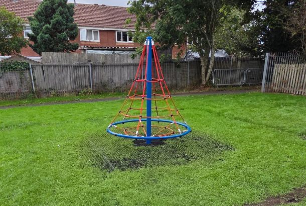 This image shows a rope net pyramid spinner on grass